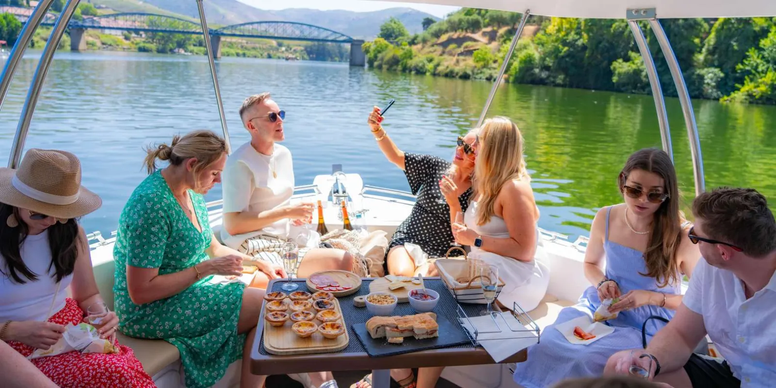 Guests sharing a picnic spread aboard the boat cruise on the Douro River